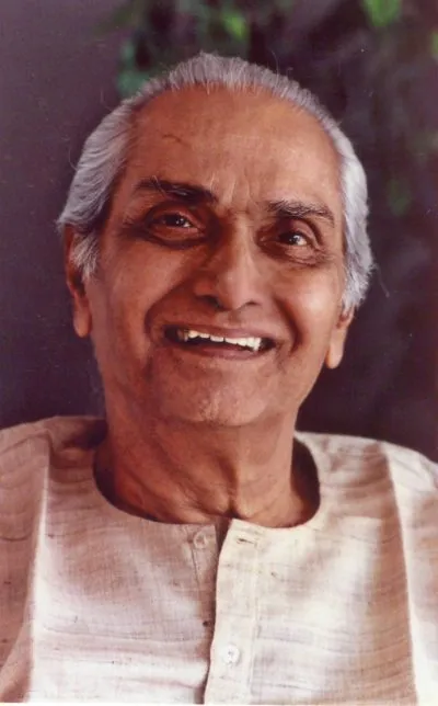 Full-length portrait of Ramesh standing by window